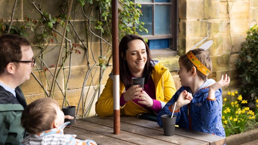 Young family enjoying the garden seating at Ormesby Hall's cafe